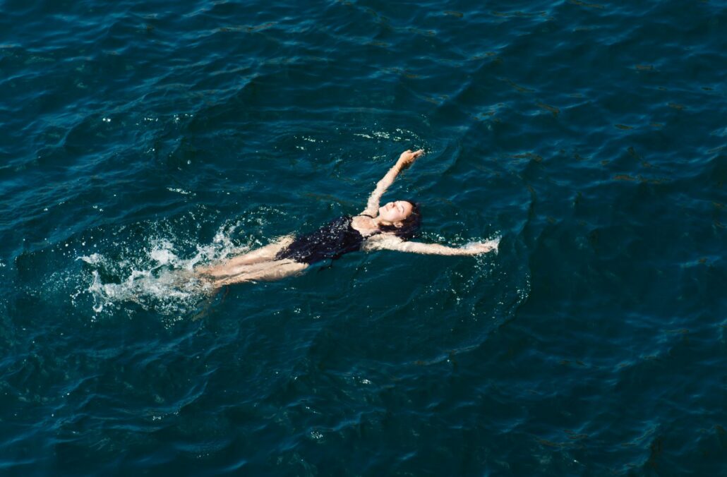 Person liegt am Rücken treibend im Meer
